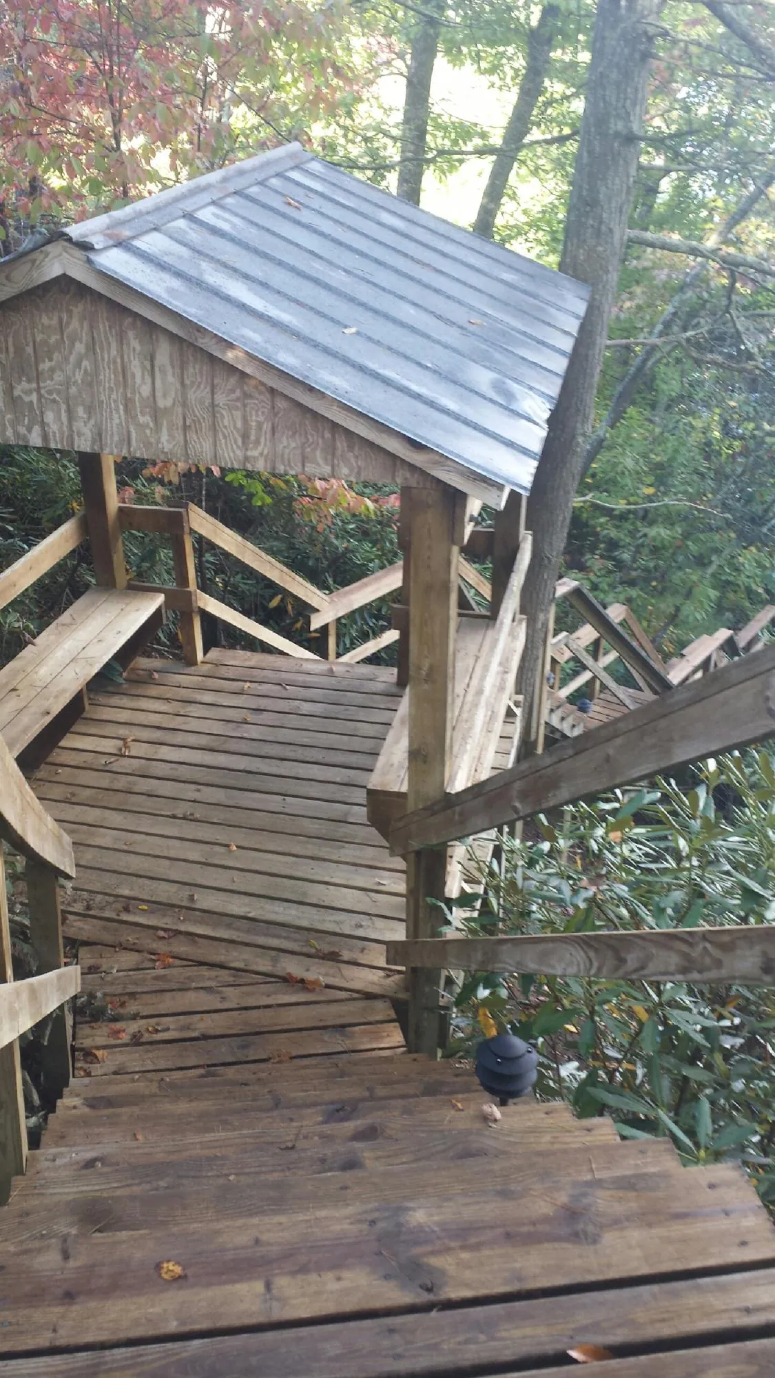 Metal roofed shelter over wooden steps on a wooded walkway — Skylight Repair & Installation work by our crew in Stevinson