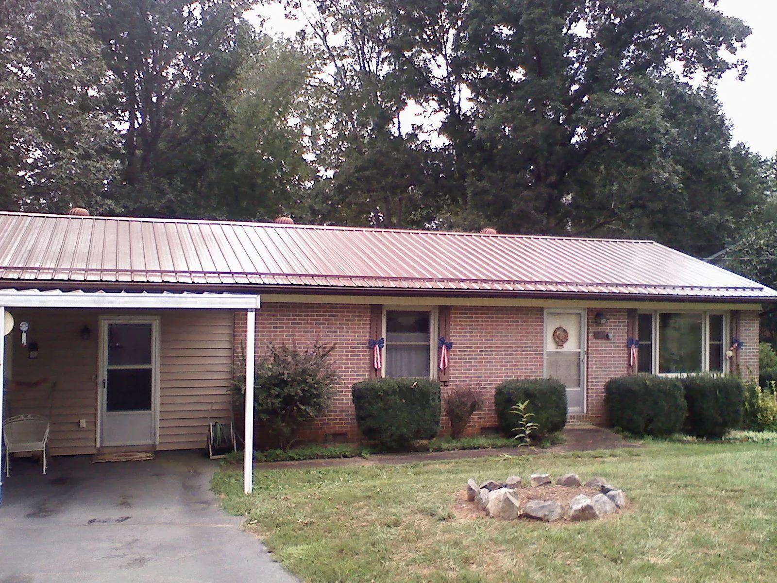 Bronze metal roof and carport on a brick ranch home — Roof Repair work by our crew in Stevinson